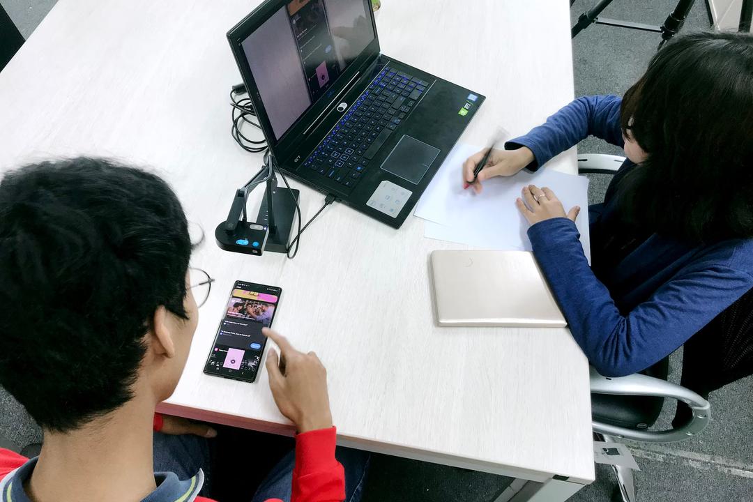 2 people doing research on a mobile phone